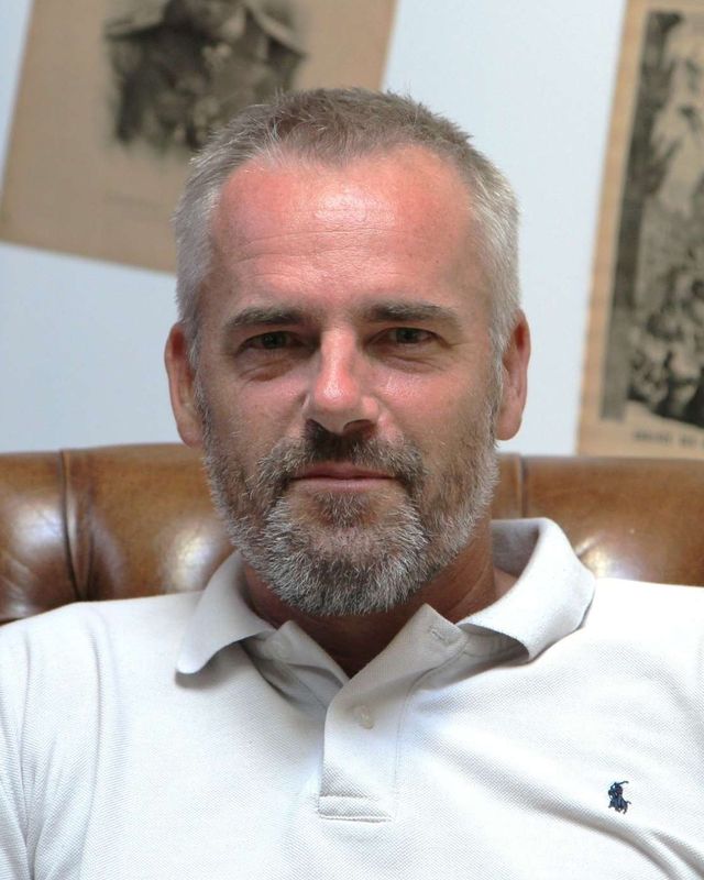Portrait de Jean-Philippe Barret, assis dans un fauteuil en cuir.